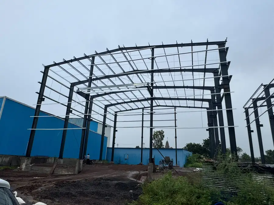 Erected shed frame alongside blue-clad existing unit