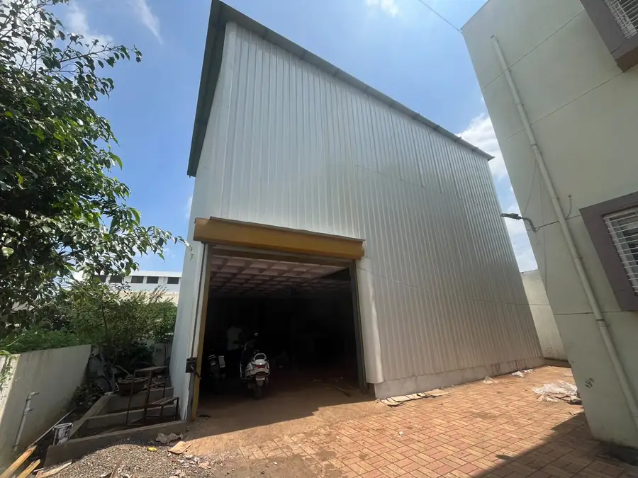 Completed industrial shed with steel sheeting and roller-shutter opening